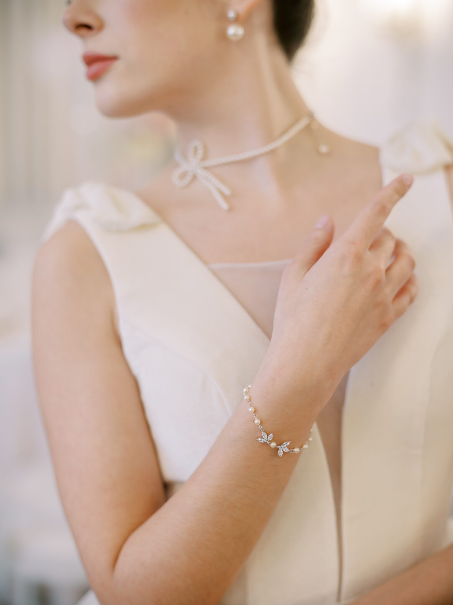 Pearl bow necklace, pearl bracelet and pearl earrings worn by bride, designed by Joanna Bisley Designs.