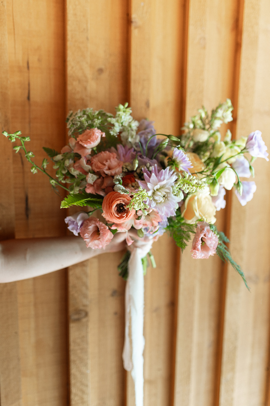 Colourful summer bridal bouquet with vibrant colours and wildflowers.